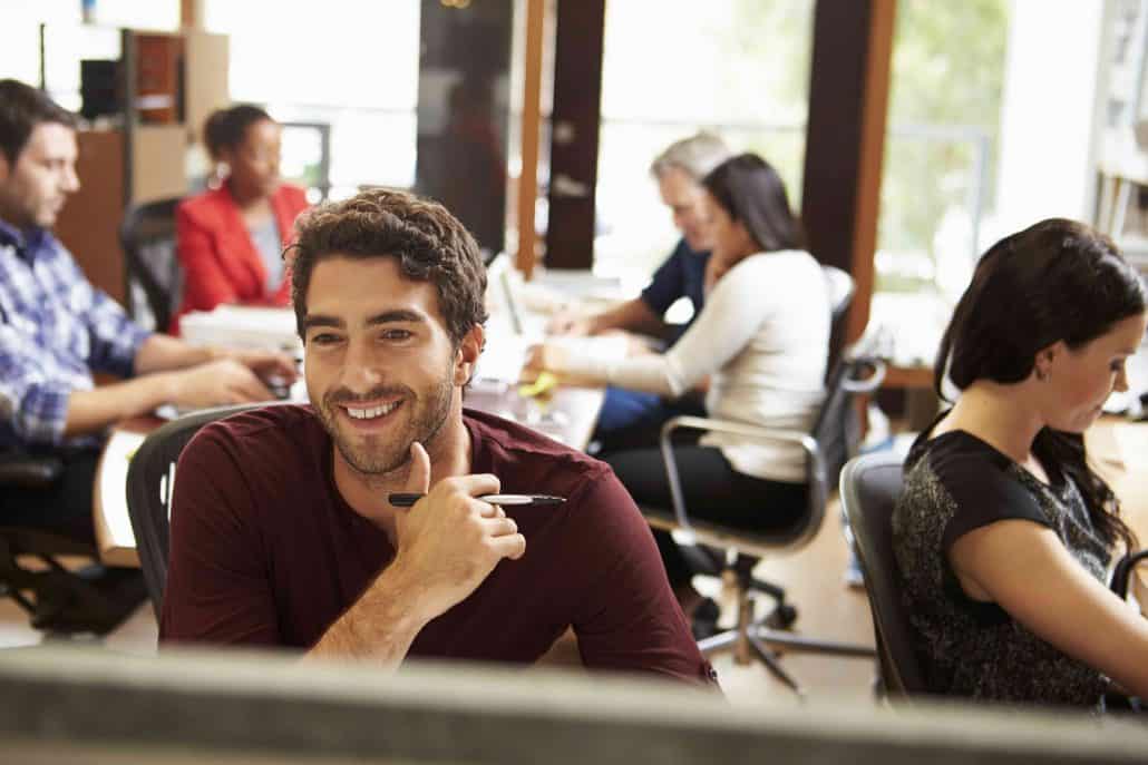 Smiling team member at work in a busy office